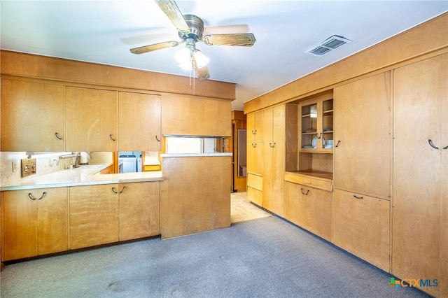 kitchen featuring kitchen peninsula, washer / clothes dryer, ceiling fan, and sink