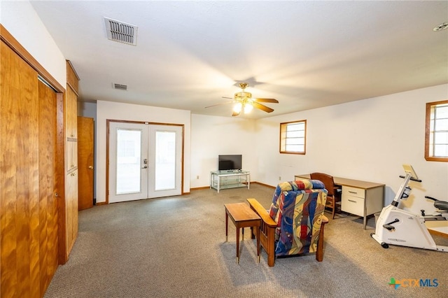 carpeted living room with french doors and ceiling fan