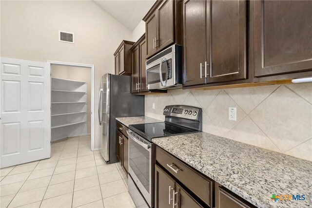6500 Mustang Creek Rd, Killeen, TX 76549 - kitchen featuring appliances with stainless steel finishes, tasteful backsplash, vaulted ceiling, dark brown cabinets, and light stone countertops