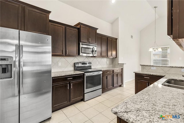 6500 Mustang Creek Rd, Killeen, TX 76549 - kitchen with appliances with stainless steel finishes, light tile patterned floors, backsplash, dark brown cabinets, and hanging light fixtures