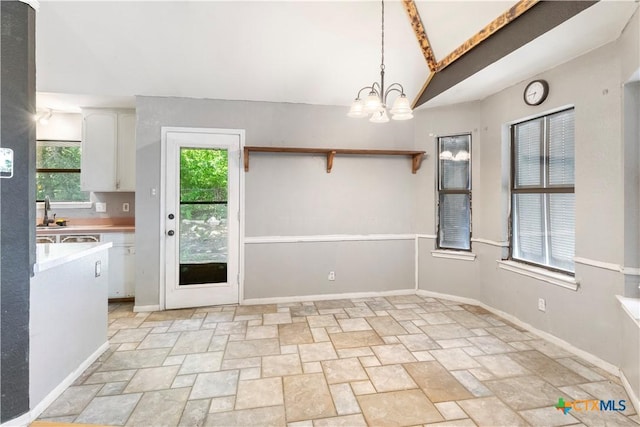 unfurnished dining area featuring plenty of natural light and a chandelier