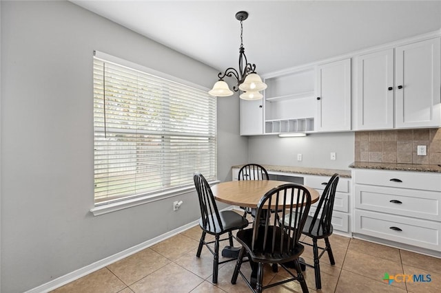 dining space with light tile patterned floors and an inviting chandelier