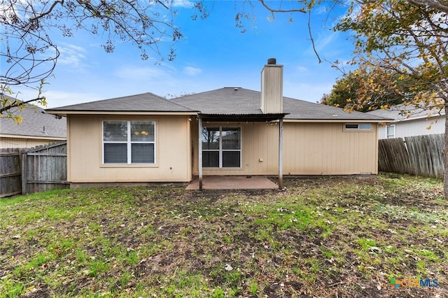 rear view of property with a lawn and a patio area