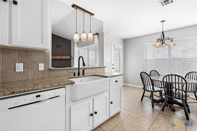 kitchen with white dishwasher, plenty of natural light, lofted ceiling, and sink