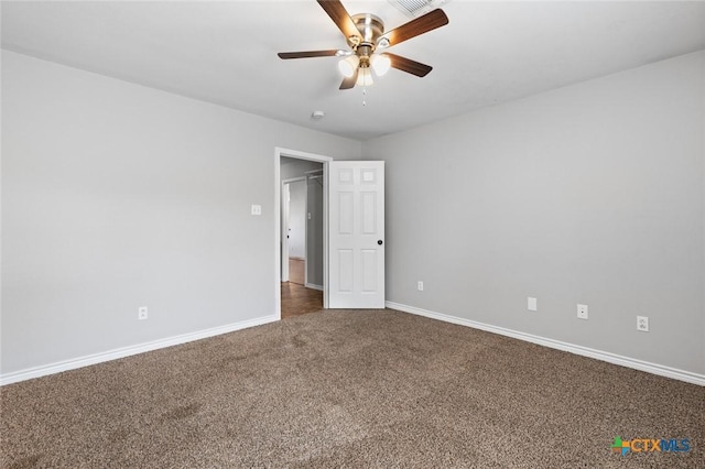 unfurnished room with dark colored carpet and ceiling fan