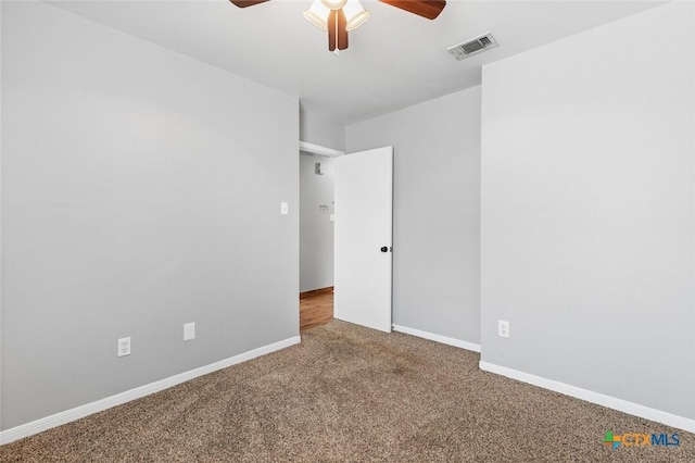 spare room with ceiling fan and carpet