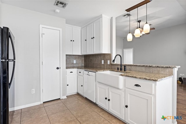 kitchen featuring white cabinetry, black fridge, kitchen peninsula, white dishwasher, and decorative light fixtures