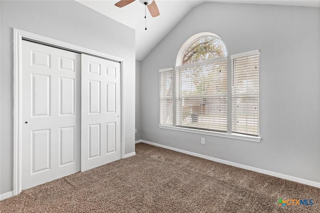 unfurnished bedroom with carpet flooring, ceiling fan, a closet, and vaulted ceiling