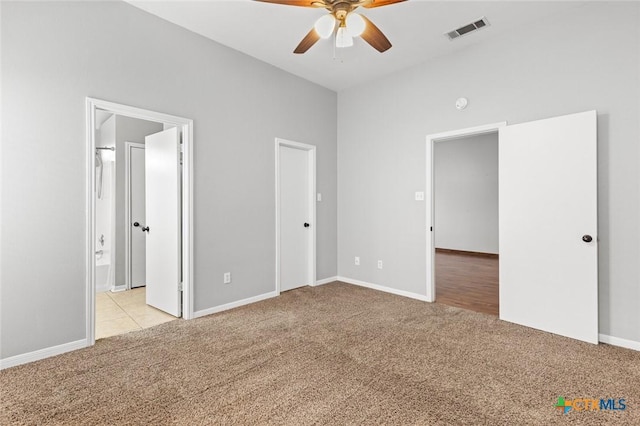 unfurnished bedroom with ensuite bathroom, ceiling fan, and light carpet