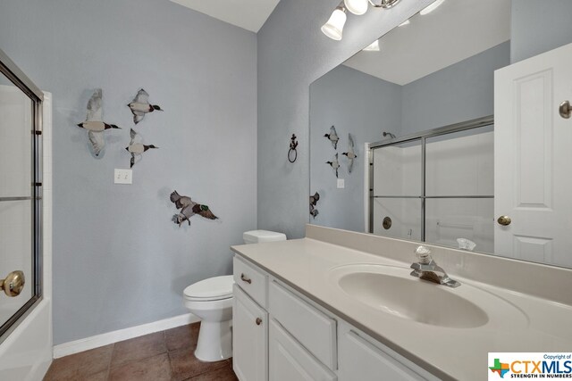 full bathroom with toilet, bath / shower combo with glass door, vanity, and tile patterned floors