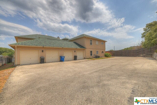 view of side of property featuring a garage and central air condition unit