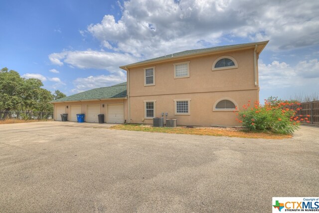 exterior space featuring a garage and central AC