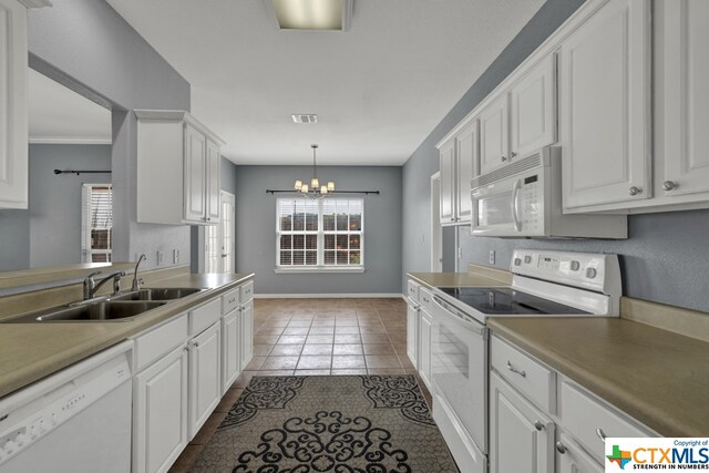 kitchen featuring white cabinetry, sink, decorative light fixtures, white appliances, and a chandelier