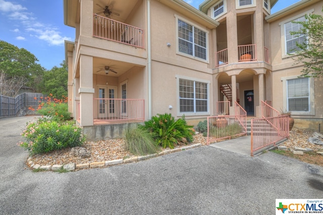 view of front of property featuring ceiling fan and a balcony