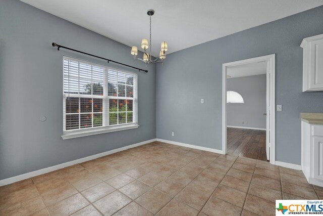 unfurnished dining area with an inviting chandelier