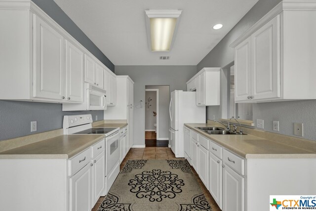 kitchen with white cabinetry, tile patterned flooring, sink, and white appliances