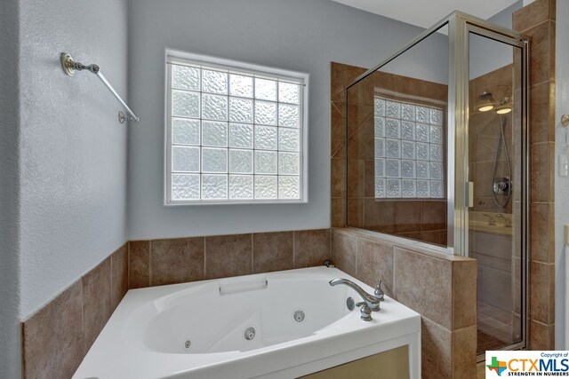 bathroom featuring shower with separate bathtub