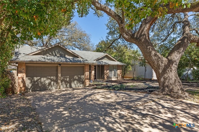 5004 Powder River Rd, Austin, TX 78759 - ranch-style home featuring brick siding, an attached garage, and concrete driveway