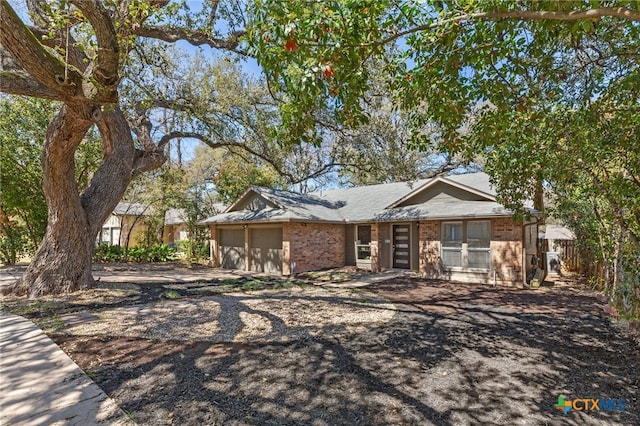 5004 Powder River Rd, Austin, TX 78759 - ranch-style house with driveway, brick siding, an attached garage, and fence