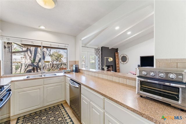 5004 Powder River Rd, Austin, TX 78759 - kitchen featuring a toaster, a fireplace, white cabinets, stainless steel appliances, and a sink