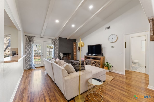 5004 Powder River Rd, Austin, TX 78759 - living room featuring visible vents, a brick fireplace, lofted ceiling with beams, and wood finished floors