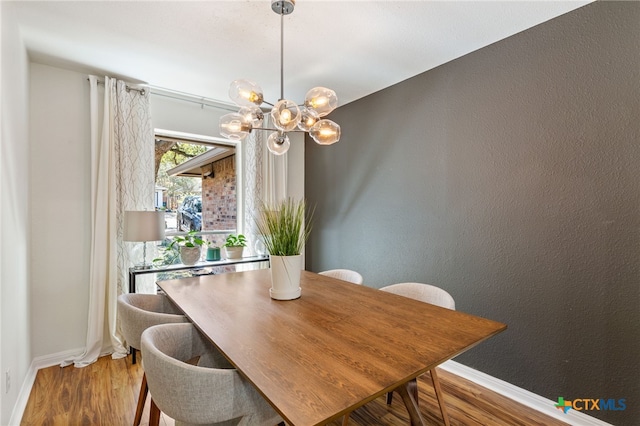 5004 Powder River Rd, Austin, TX 78759 - dining area with baseboards, a notable chandelier, wood finished floors, and a textured wall