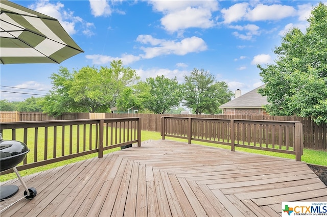 wooden deck featuring a lawn