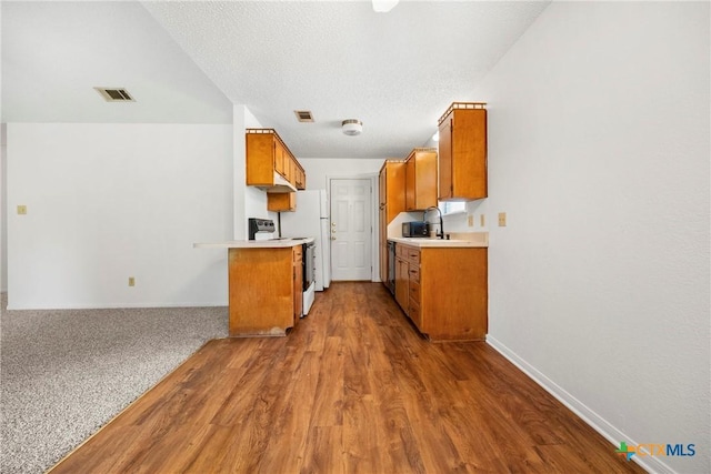 312 Saddle Dr, Copperas Cove, TX 76522 - kitchen with electric range, brown cabinetry, light countertops, and wood finished floors