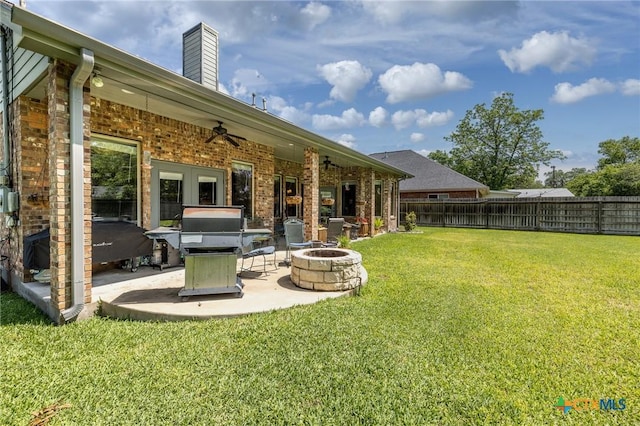 view of yard with ceiling fan, a fire pit, a fenced backyard, and a patio area
