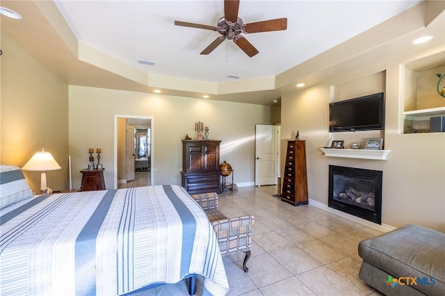 bedroom featuring recessed lighting, light tile patterned floors, a glass covered fireplace, visible vents, and baseboards