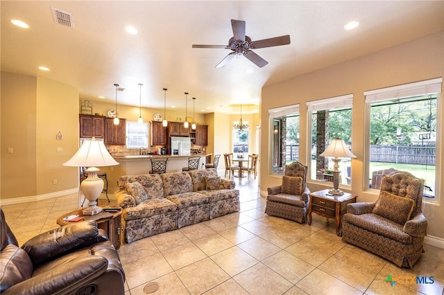 living room featuring baseboards, visible vents, light tile patterned flooring, and recessed lighting