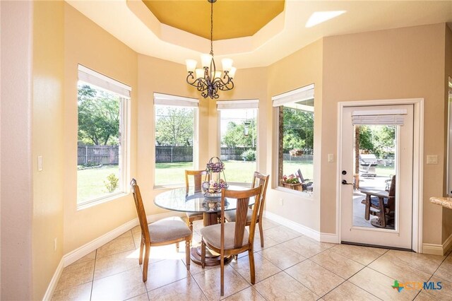 dining space featuring light tile patterned flooring, a notable chandelier, and baseboards