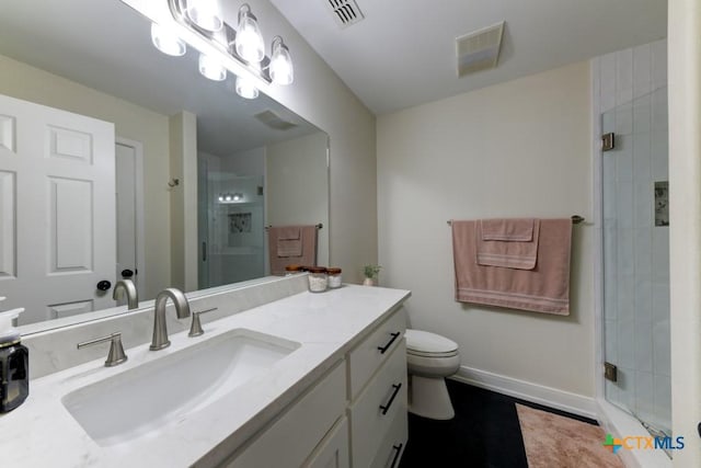 bathroom with vanity, toilet, and a shower with shower door