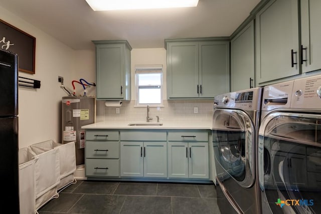 laundry area with sink, washer and clothes dryer, dark tile patterned floors, cabinets, and electric water heater