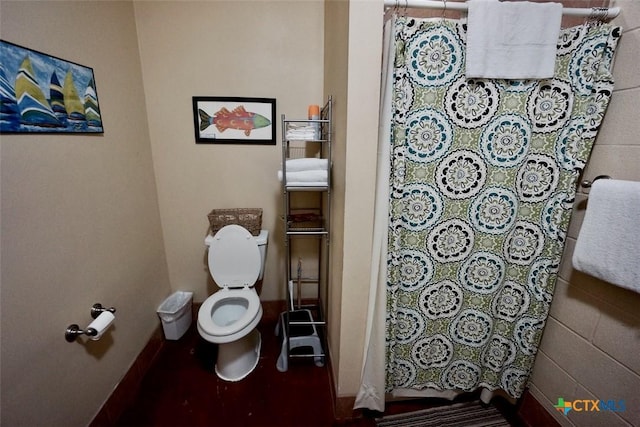 bathroom featuring curtained shower and toilet