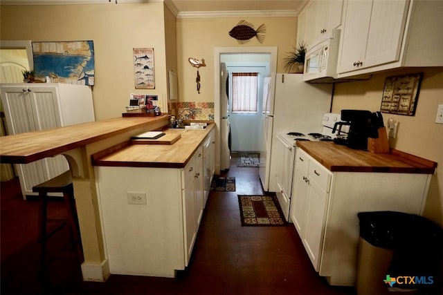 kitchen with a sink, wood counters, white appliances, and a peninsula