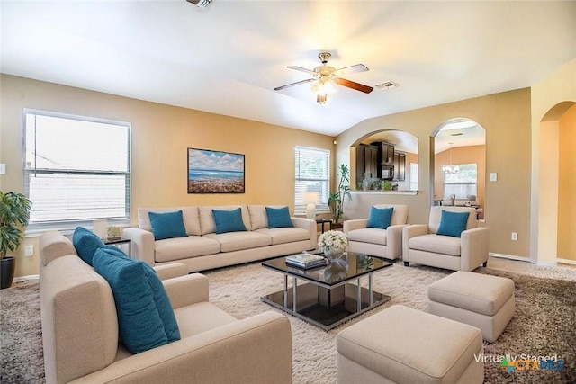 living area with arched walkways, a ceiling fan, visible vents, and plenty of natural light
