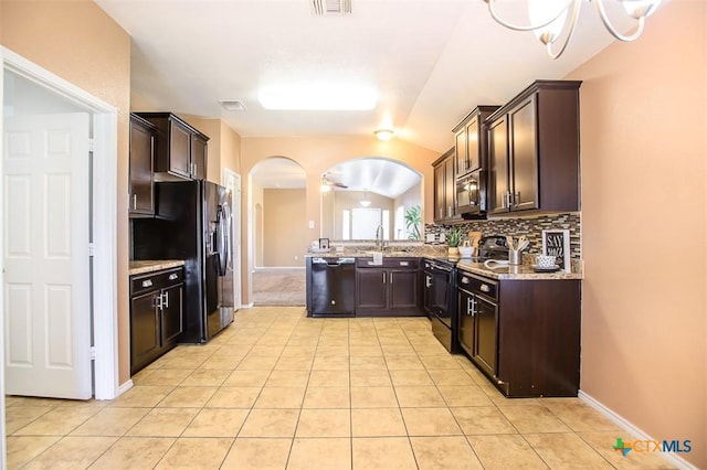 kitchen featuring backsplash, dark brown cabinets, a sink, arched walkways, and black appliances