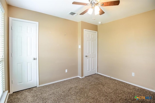 unfurnished bedroom with visible vents, carpet flooring, baseboards, and a ceiling fan