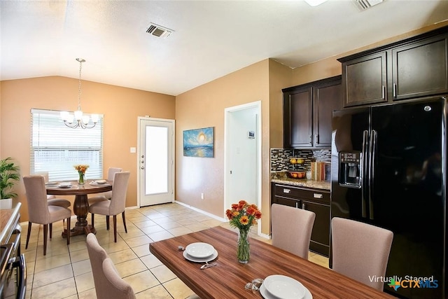 dining area with lofted ceiling, visible vents, light tile patterned flooring, baseboards, and a chandelier