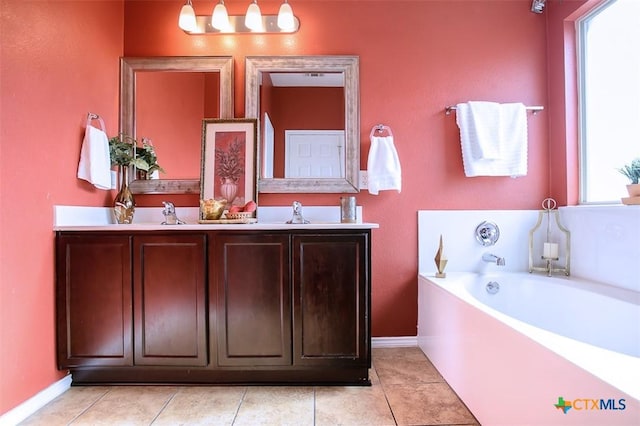 full bath featuring a garden tub, a sink, double vanity, and baseboards