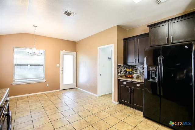 kitchen featuring decorative backsplash, light tile patterned flooring, a notable chandelier, black fridge, and visible vents