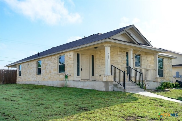 view of front of home featuring stone siding, a front lawn, and fence