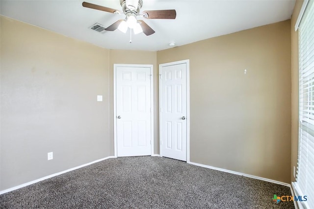 unfurnished bedroom with carpet flooring, visible vents, baseboards, a ceiling fan, and a closet