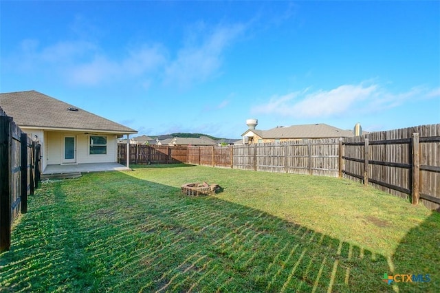 view of yard with a fenced backyard, a patio, and an outdoor fire pit