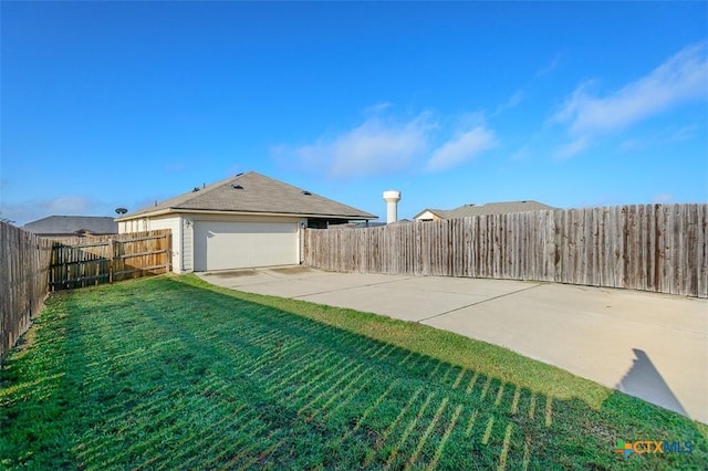 view of yard featuring a garage and a fenced backyard