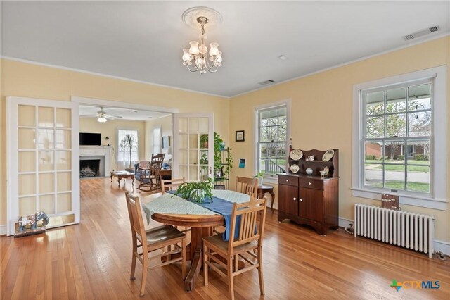 505 N 7th St, Temple, TX 76501 - dining room with a fireplace, light wood-style flooring, crown molding, radiator heating unit, and visible vents