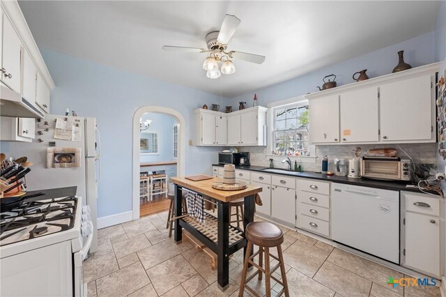505 N 7th St, Temple, TX 76501 - kitchen with white appliances, backsplash, white cabinets, ceiling fan, and arched walkways