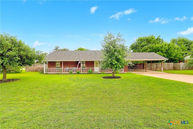 ranch-style home featuring a porch, fence, a front yard, and concrete driveway