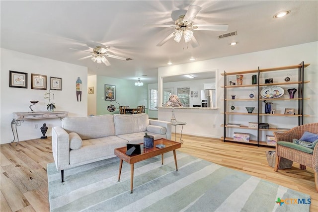 living area with a ceiling fan, visible vents, light wood-style flooring, and recessed lighting